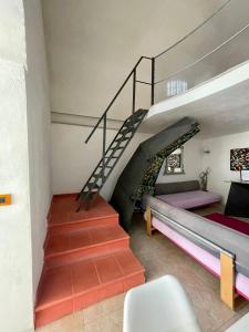 Cette chambre dispose d'un escalier, d'un lit et d'un canapé. dans l'établissement Il Giardino dei Limoni, à Vieste