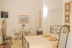 a bedroom with a bed and a table and chairs at B&B Tenuta Martinelli in Monopoli