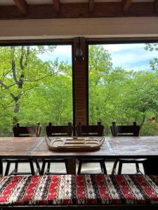 a table in a room with a large window at Villa Vejini cabin in Mamkoda