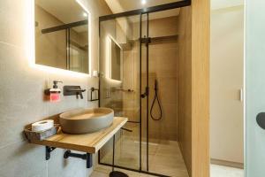 La salle de bains est pourvue d'un lavabo et d'une douche. dans l'établissement Napoleon Apartments, à Paleokastritsa