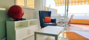 - un salon avec une chaise et une table dans l'établissement Apartamento Naranja, incredible ocean view, à Puerto de Santiago