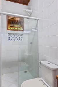 a bathroom with a glass shower with a toilet at Aldeia dos Corais - Taipu de Fora in Barra Grande
