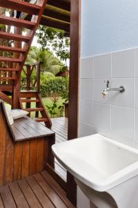 a bathroom with a tub and a sink on a deck at Aldeia dos Corais - Taipu de Fora in Barra Grande