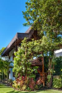 a house with a tree in front of it at Aldeia dos Corais - Taipu de Fora in Barra Grande