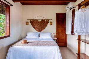 a bedroom with a bed with a hat on it at Aldeia dos Corais - Taipu de Fora in Barra Grande