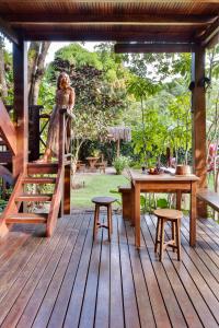 a woman is standing on a wooden deck at Aldeia dos Corais - Taipu de Fora in Barra Grande