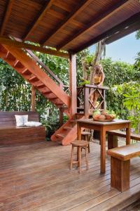 a woman is sitting on a wooden deck at Aldeia dos Corais - Taipu de Fora in Barra Grande