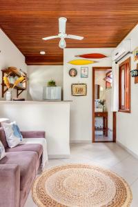 a living room with a couch and a ceiling fan at Aldeia dos Corais - Taipu de Fora in Barra Grande