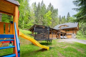a playground with a slide in front of a cabin at Wellness Zrub Durik Bystra in Horná Lehota +69 photos