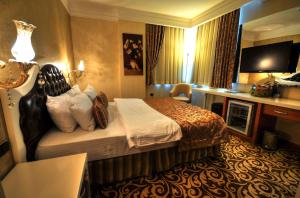 A bed or beds in a room at Golden Deluxe Hotel