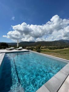 una piscina con vista sulle montagne di Hôtel Guest House Baritedda a Pianottoli-Caldarello