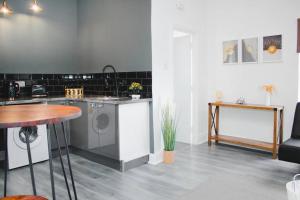 eine Küche mit einer Waschmaschine und einem Tisch in der Unterkunft All-Inclusive Living: Modern Studio in Liverpool