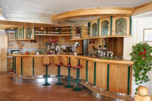 a kitchen with a bar with stools in front of it at Gasthaus Bacher in Sankt Johann im Pongau +14 photos