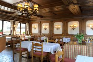 a restaurant with tables and chairs and a chandelier at Gasthaus Bacher in Sankt Johann im Pongau