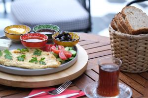 a plate of food on a table with a basket of bread at Wolf Suites in Antalya