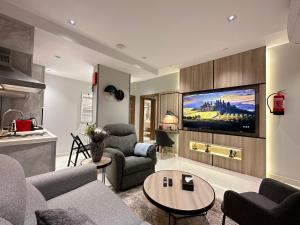 ein Wohnzimmer mit einem Sofa und einem TV in der Unterkunft Jeddah Luxury stay for Self Check-In Apartment in Dschidda