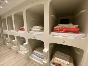 ein Schrank mit weißen Regalen und gefalteten Handtüchern in der Unterkunft Hostel The Golden Stork in Den Haag