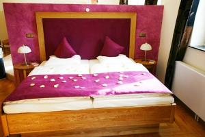 a bedroom with a large bed with a purple headboard at Rüter's Hotel & Restaurant in Salzhausen +18 photos