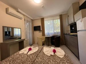 Brilliant Aparthotel في سوزوبول: غرفة نوم مع سرير مع بعرصي حمراء