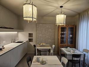 cocina y comedor con 2 mesas y 2 lámparas de araña en Piccola Dimora Gherardini, en SantʼElpidio a Mare