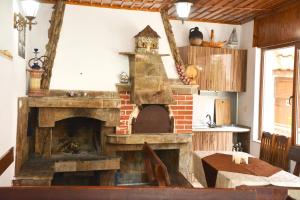 una chimenea antigua en una cocina con mesa y sidx de mesa en Ивелия Къща за гости, en Dospat