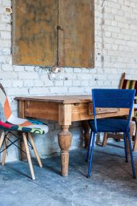 einen Holztisch und zwei Stühle neben einer Wand in der Unterkunft CAMP Agroturystyka Gorzelnia Gwieździn in Gwieździn