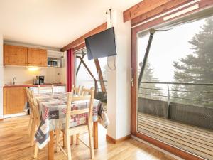 a kitchen and dining room with a table and a large window at V du Bachat - A21 Arolles - Appart spacieux 8pers in Chamrousse
