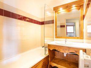 a bathroom with a sink and a tub and a mirror at V du Bachat - A21 Arolles - Appart spacieux 8pers in Chamrousse
