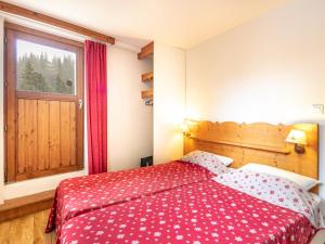 a bedroom with a bed with a red blanket and a window at V du Bachat - A21 Arolles - Appart spacieux 8pers in Chamrousse