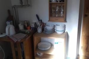 a kitchen with a counter with plates on a shelf at Návrat do starých časů, ubytování květen - září in Slabce
