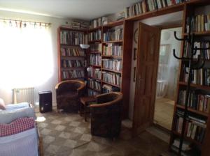 uma biblioteca com duas cadeiras e estantes cheias de livros em Návrat do starých časů, ubytování květen - září em Slabetz