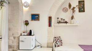 Cette chambre blanche dispose d'un réfrigérateur et d'un canapé. dans l'établissement Il Giardino dei Limoni, à Vieste