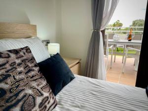 a bedroom with a bed and a balcony with a table at Casa Mae in Caleta De Fuste +42 photos
