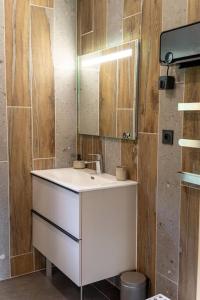 a bathroom with a white sink and a mirror at Chalet au coeur du Jura à 5min de la plage de Clairvaux 