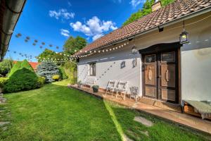 einen Hinterhof eines weißen Hauses mit Rasen in der Unterkunft Chaloupka u potoka in Kutná Hora