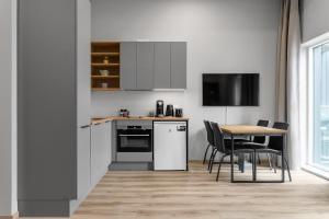 a kitchen with a table and chairs and a television at Cozy Studio Apartment in Reykjavík