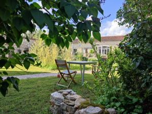 einen Tisch und einen Stuhl im Garten in der Unterkunft A deux pas de St Cirq Lapopie, La chambre du "cocher" des Murets de L'isa in Esclauzels