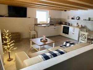a living room with a couch and a table and a kitchen at Domček pod Orechom in Blatnica