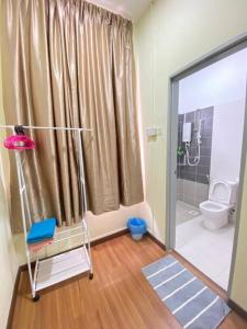 ein Badezimmer mit einer Dusche, einem WC und einer Glastür in der Unterkunft Patience Homestay Kuala Selangor in Kuala Selangor