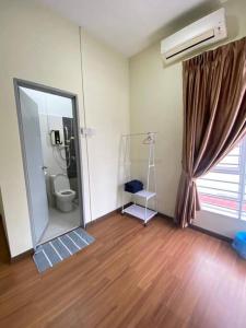 La salle de bains est pourvue de toilettes et d'un grand miroir. dans l'établissement Patience Homestay Kuala Selangor, à Kuala Selangor