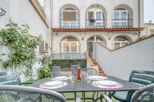 a table and chairs on a patio with a building at Mestral 1 1 Roses - Immo Barneda in Roses