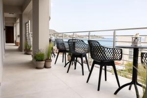 balkon z krzesłami i stołami oraz widokiem na ocean w obiekcie Niro Beachfront Living w mieście Stalida