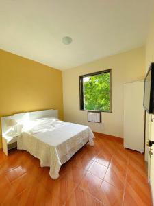 a bedroom with a white bed and a window at Hotel Boavista in Miguel Pereira