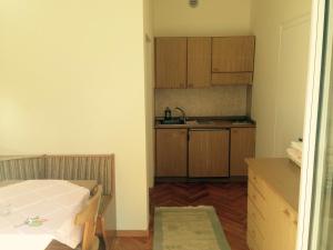 メラーノにあるResidence Hubertusの小さな客室で、キッチン(木製キャビネット付)が備わります。