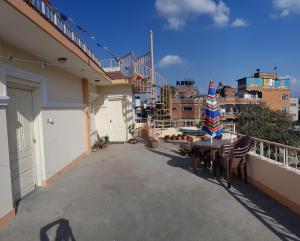 patio con mesa y sillas en el balcón en Rooftop Studio and 2BHK Apartments in Kathmandu's most happening place, en Katmandú