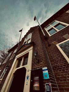 um edifício de tijolos com uma bandeira em cima em Boutique Hotel het Oude Raadhuis em Castricum