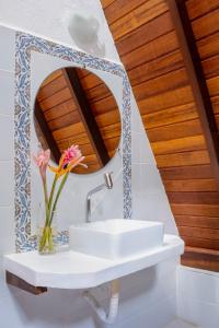 a bathroom with a sink and a mirror at Aldeia dos Corais - Taipu de Fora in Barra Grande