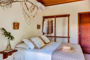 a bedroom with a bed with a hat on it at Aldeia dos Corais - Taipu de Fora in Barra Grande