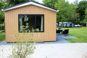 a small building with a table and a tent at Chalet Merel in Drijber