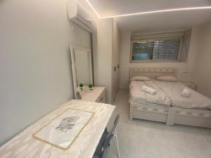 ein kleines Schlafzimmer mit einem Bett und einem Tisch in der Unterkunft דירת בוטיק - Boutique apartment in Bayit Wegan